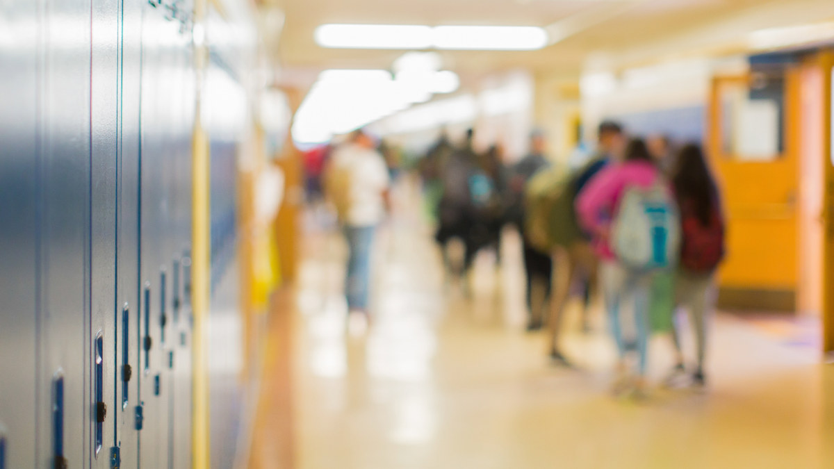 A school hallway lined with lockers, students walking between classes